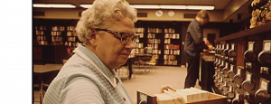 older female librarian sorting a cart catalog