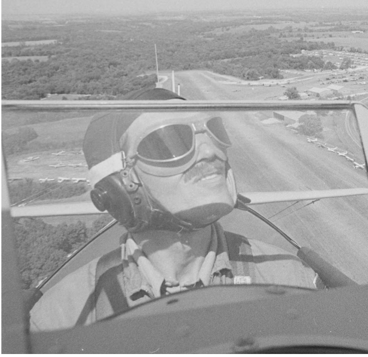 The same pilot photo cropped close around the pilot, so the expanse of surrounding fields in the background is no longer shown.