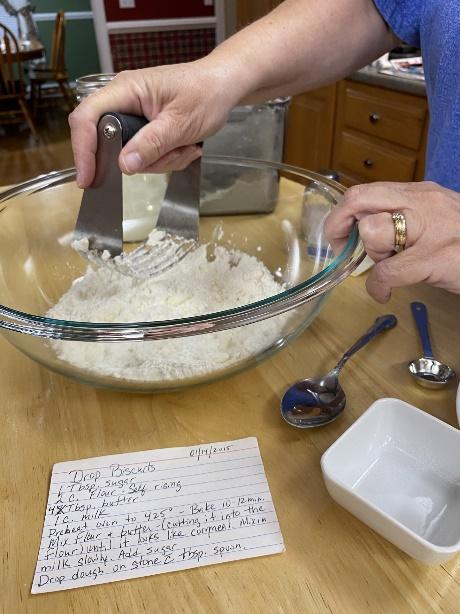 My mom cutting the butter into the flour forming a cornmeal like texture.