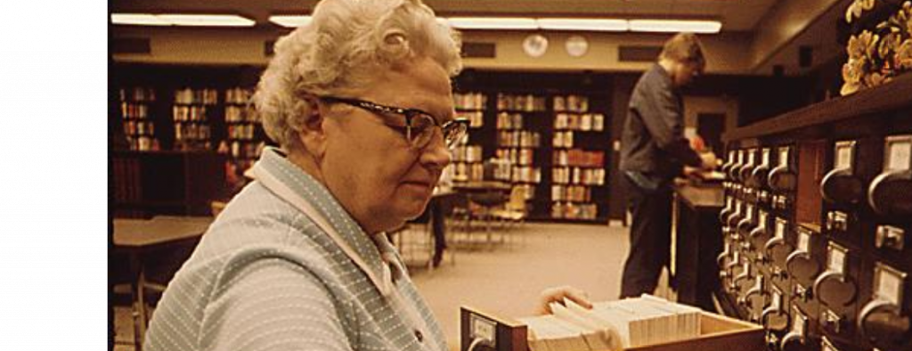 older female librarian sorting a cart catalog