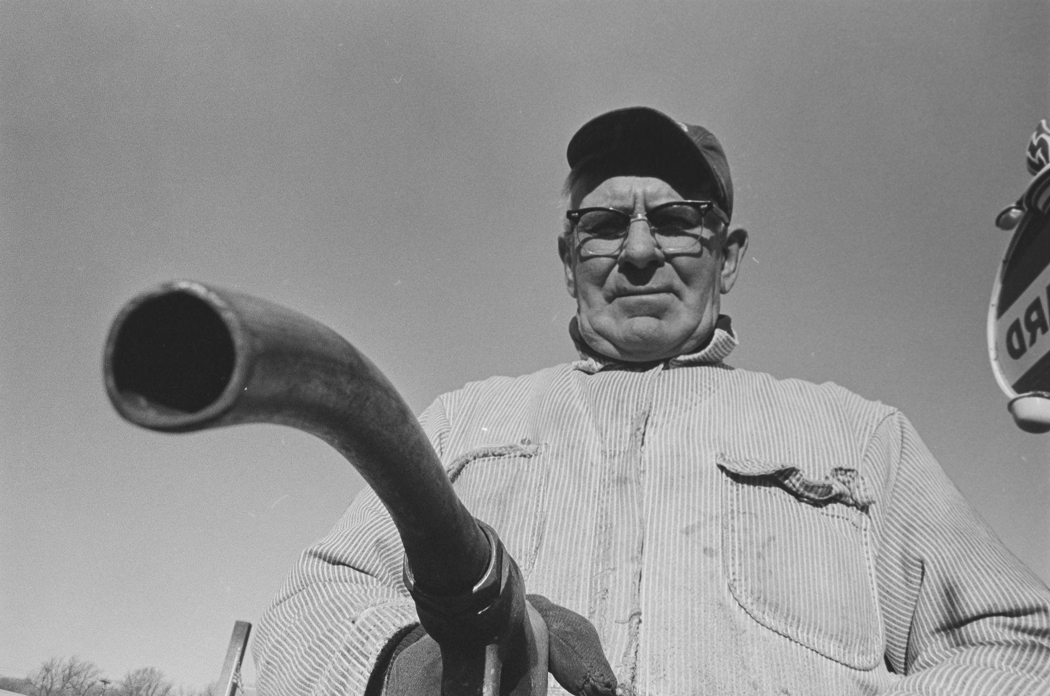 A man holds a pipe in his hands and looks down on it. 