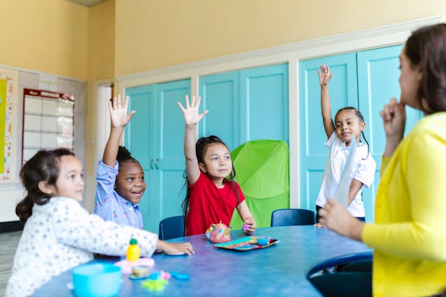 Students with raised hands in a classroom