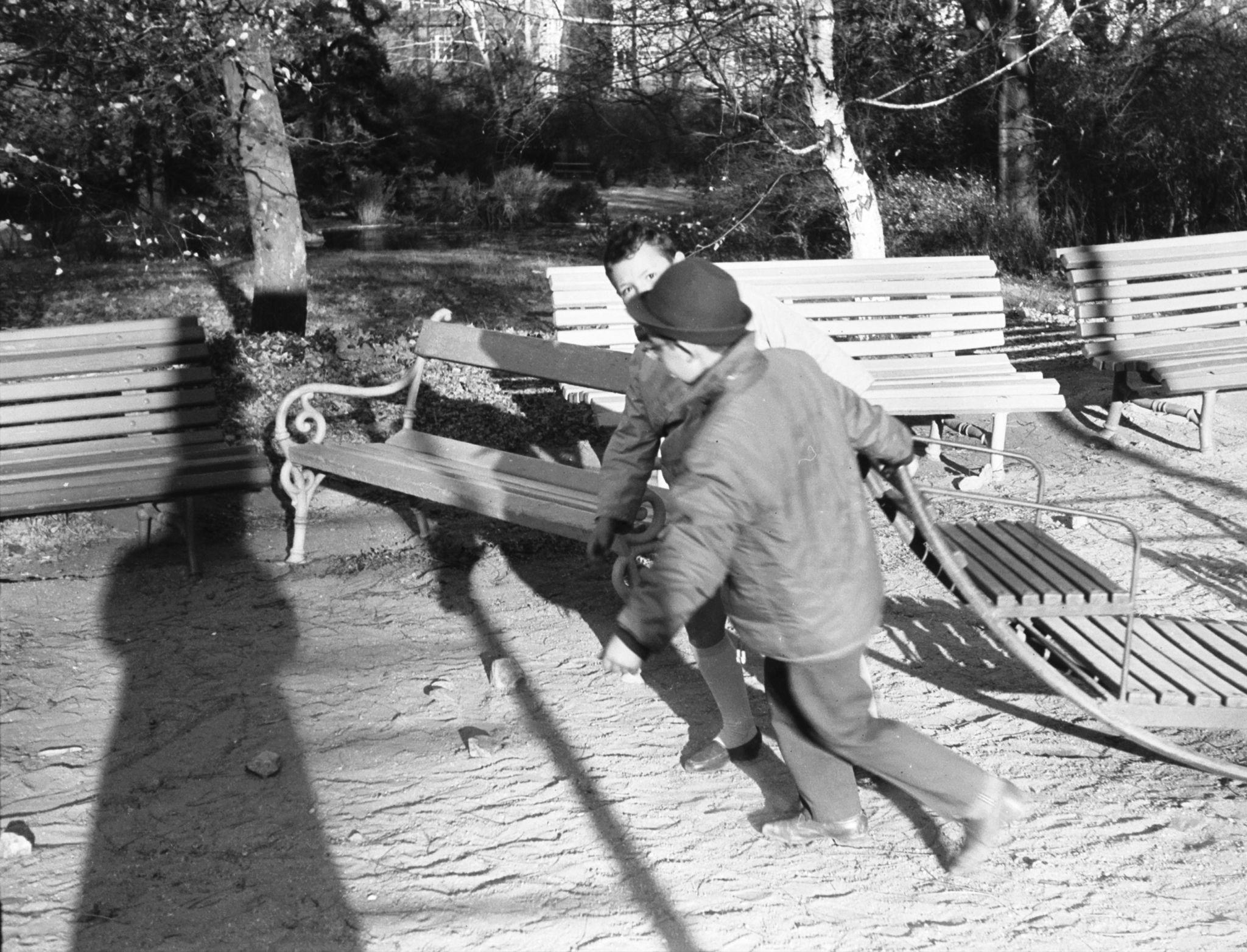 A reverse version of the image of 2 young boys pulling a sled.