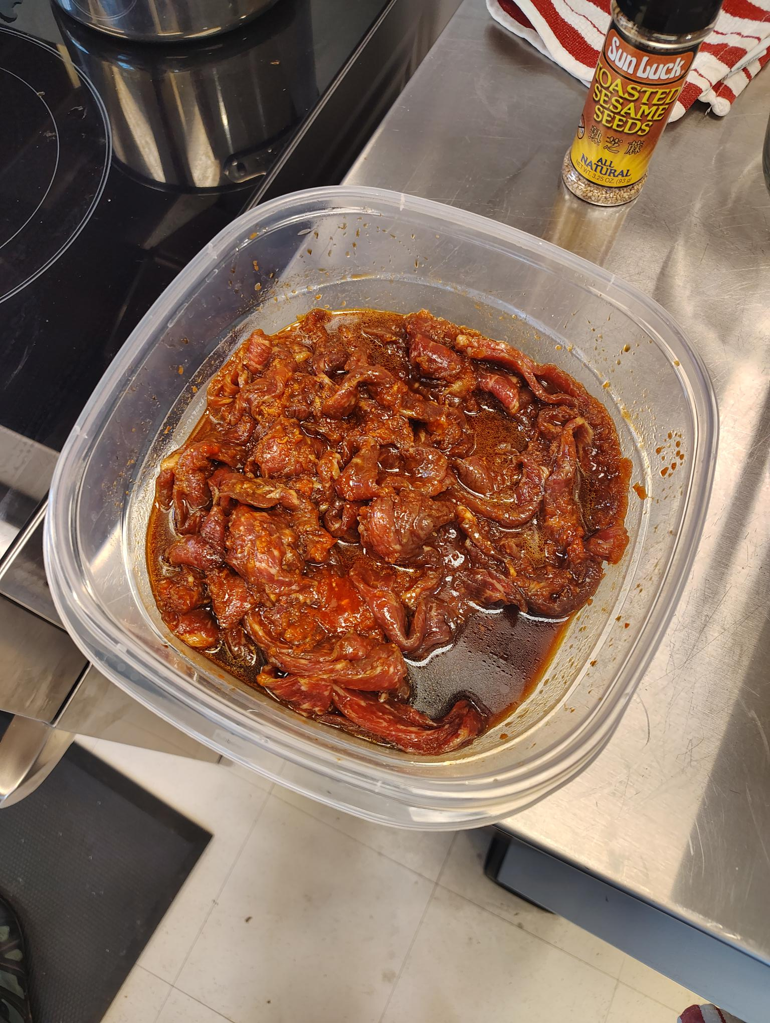 beef stir-fry meat marinating in soy sauce mixture in a bowl