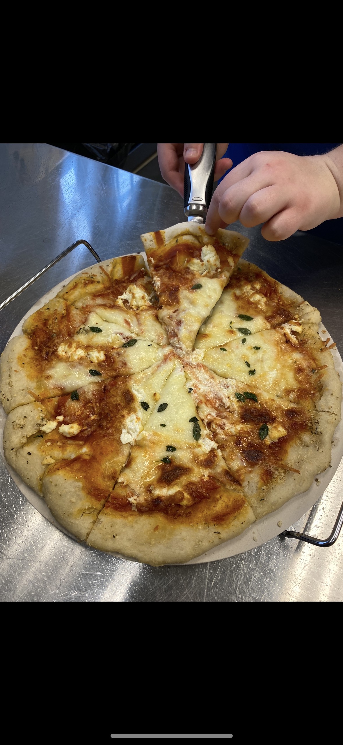 A gooey 4 cheese pizza, with golden brown crust. A perfect slice lifts into the air on a pie slicer with a ooey, gooey cheese pull. 