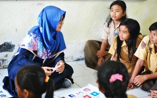 Students in Indonesia gather around their teacher