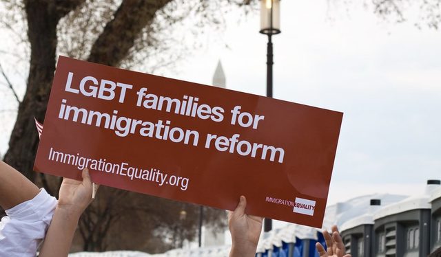 An activist holds a sign that reads “LGBT Families for Immigration Reform”