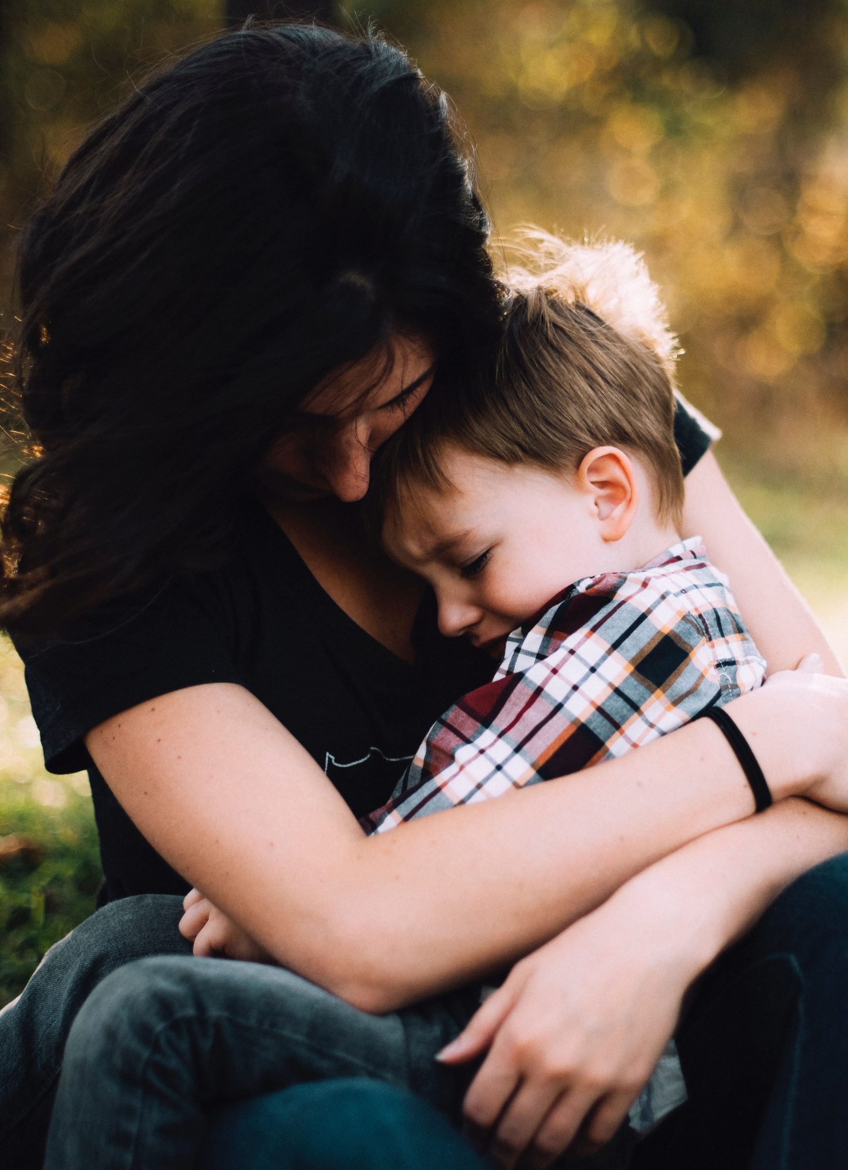 A mother comforts a child on her lap