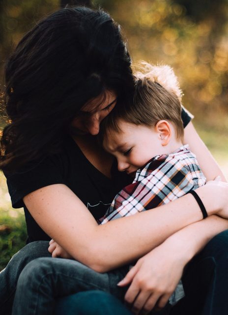 A mother comforts a child on her lap