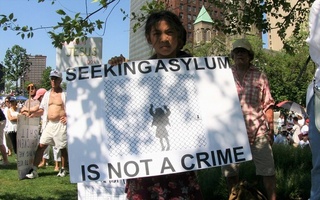 An activist at a rally against family separation in Cleveland, Ohio, holds a sign stating “Seeking Asylum in Not a Crime”