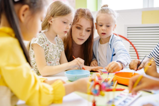 A teacher and students using water colors