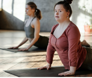 Two people doing yoga. One of them has Down syndrome