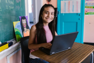 A middle school student at her desk with a laptop