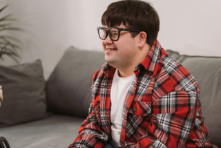 A person with Down syndrome sitting on a couch