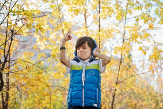 A child wearing headphones and holding his hands up