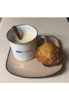 Arroz con leche in a University of Northern Iowa mug next to a pastry